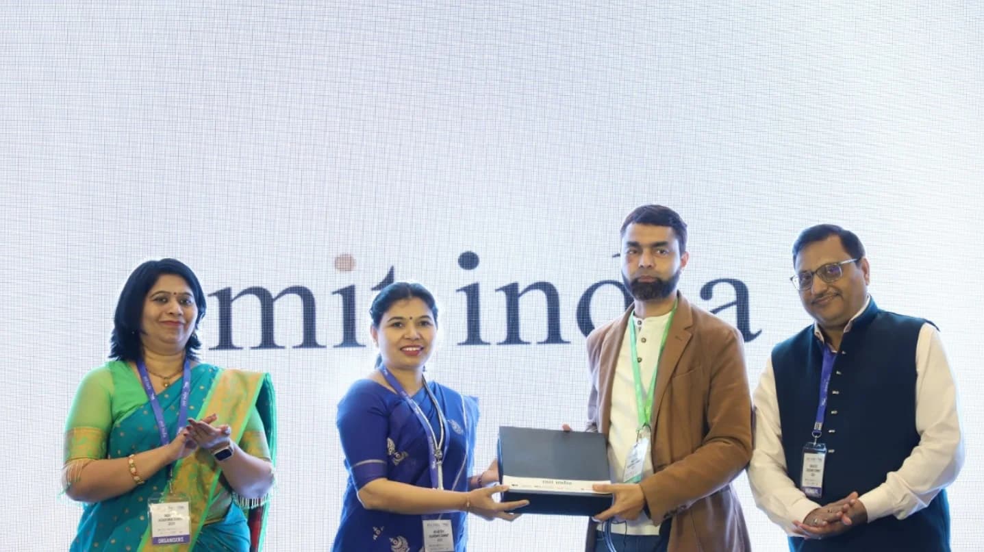 Technologics Global receiving recognition on stage at the AMIT India conference