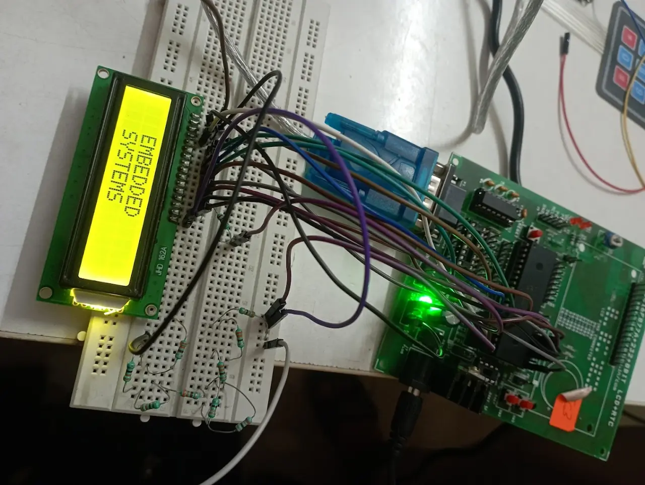 Candidate breadboard build driving an LCD that reads "Embedded Systems" from an 8051 trainer board at Technologics Global