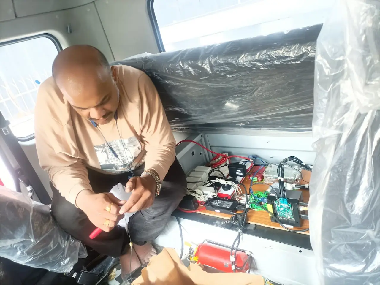 Technologics Global engineer wiring the embedded control hardware during an in-vehicle installation